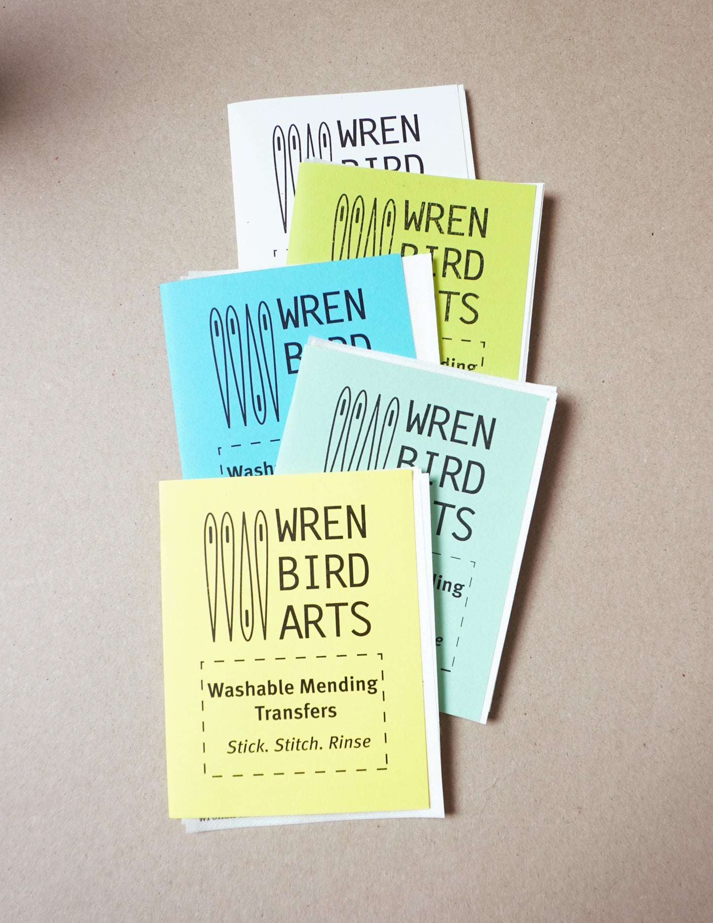 Set of Wren Bird Arts washable mending transfers on a beige background